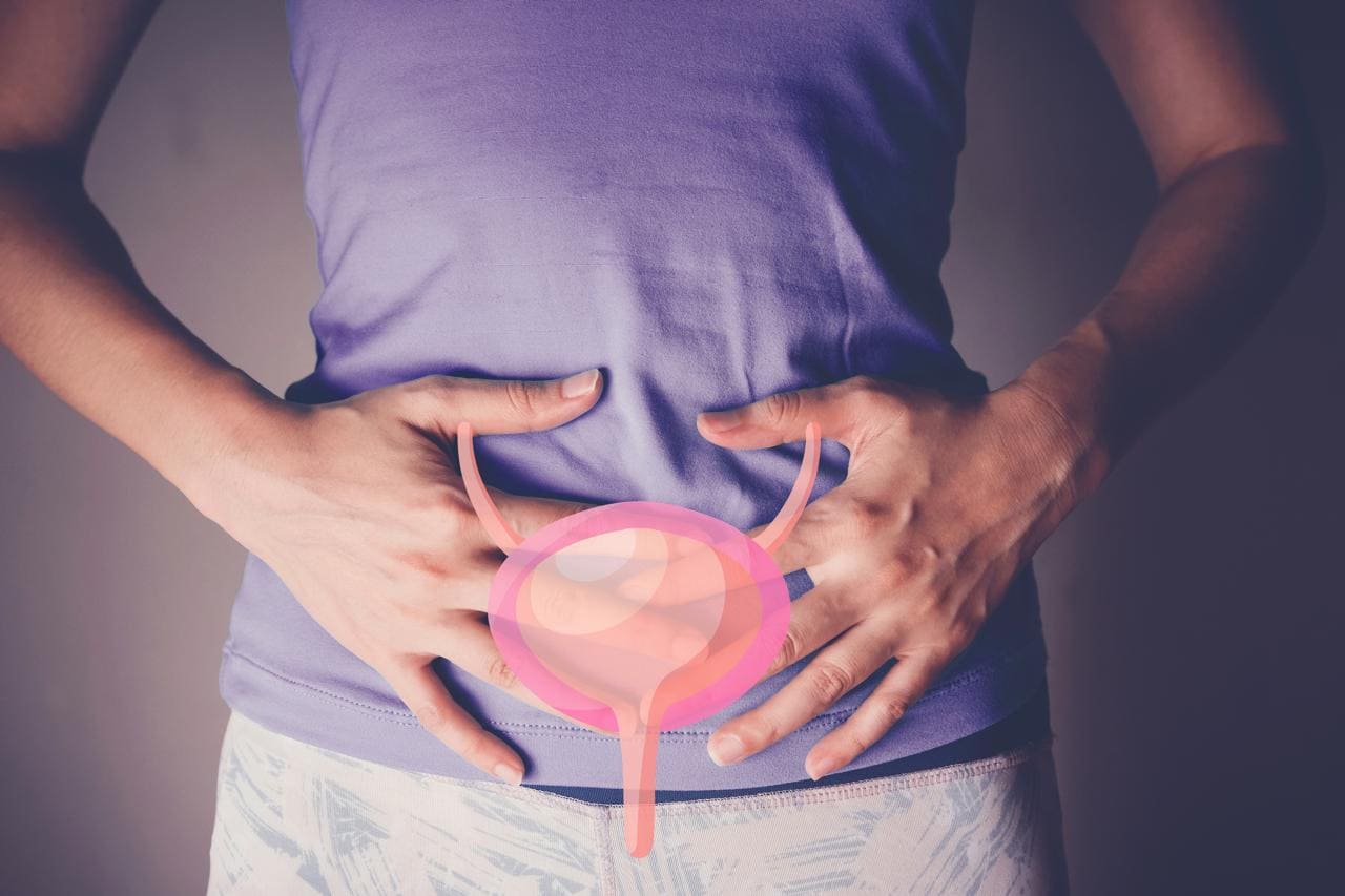 Una mujer con ambas manos en su estómago.